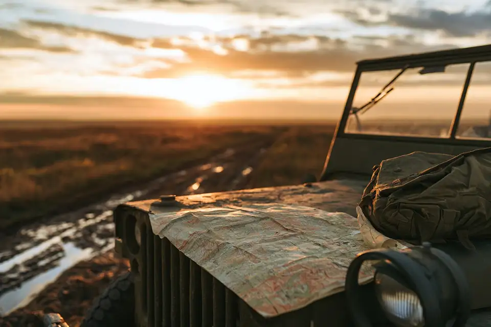Patton debout dans une jeep, casque, carte dépliée sur les genoux.